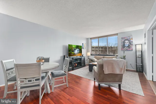 a living room with furniture a flat screen tv and a table
