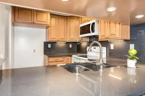 a kitchen with stainless steel appliances granite countertop a sink stove and microwave