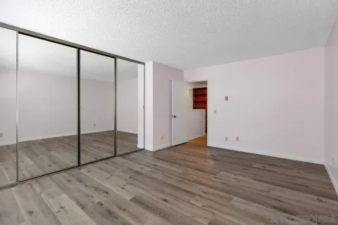 an empty room with wooden floor and mirror