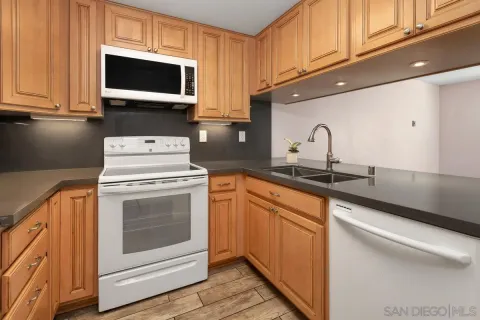a kitchen with stainless steel appliances granite countertop a sink a stove and microwave