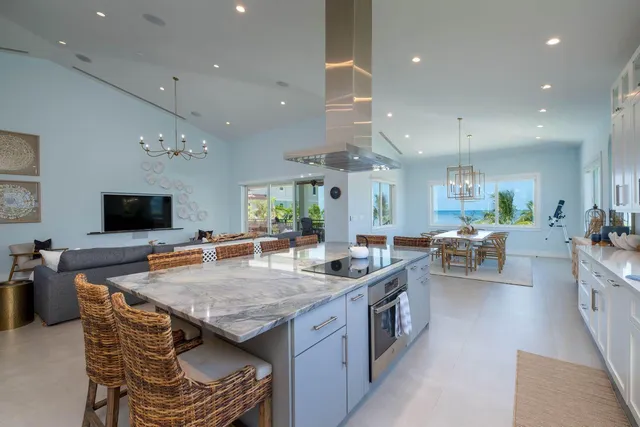 a living room with furniture a flat screen tv and kitchen view