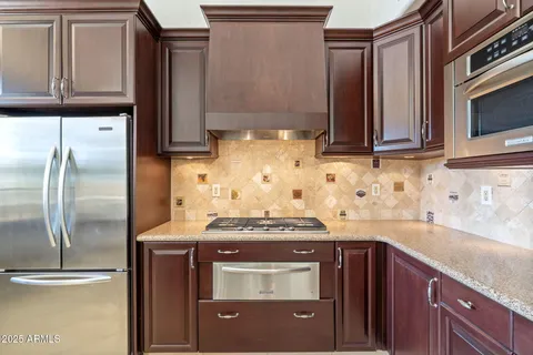 a kitchen with granite countertop a sink stove and refrigerator
