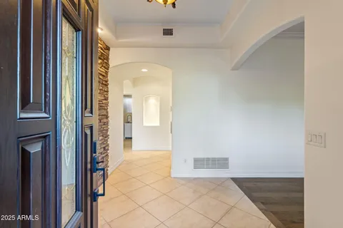 a view of a hallway with wooden floor and a bathroom