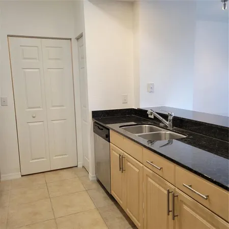 a kitchen with granite countertop white cabinets and sink