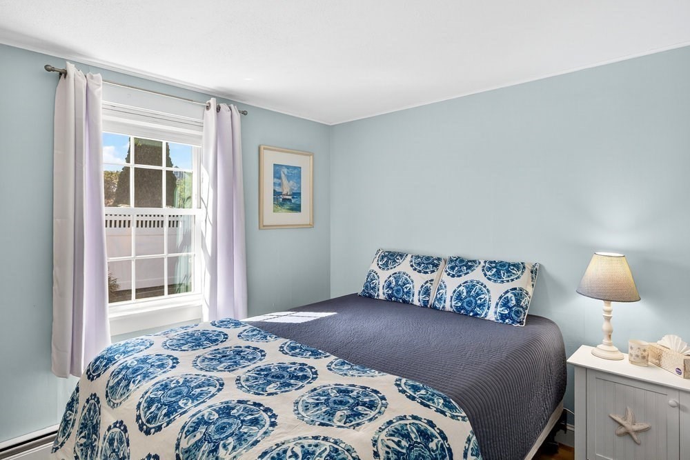 40 Shore Road Dennis, MA 02670 - Photo 19 of 34 a bedroom with a bed and lamp