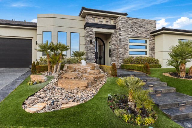 3022 West Sesia Way St. George, UT 84770 - Photo 12 of 52 View of front of home with stone siding, stucco siding, an attached garage, and driveway