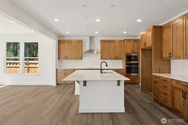 a kitchen with stainless steel appliances granite countertop a sink a stove and a refrigerator