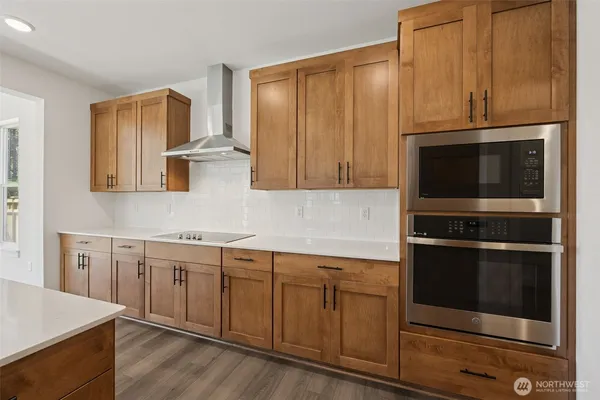 a kitchen with stainless steel appliances white cabinets and a stove top oven