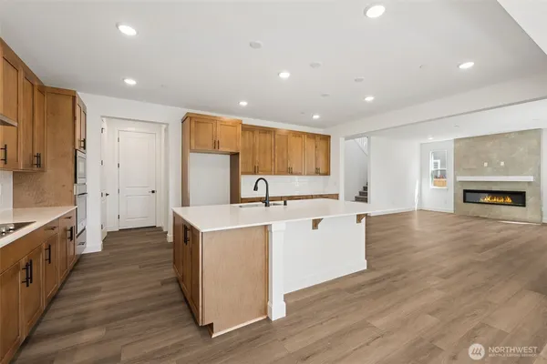 a large kitchen with stainless steel appliances kitchen island a large counter top and a wooden floors