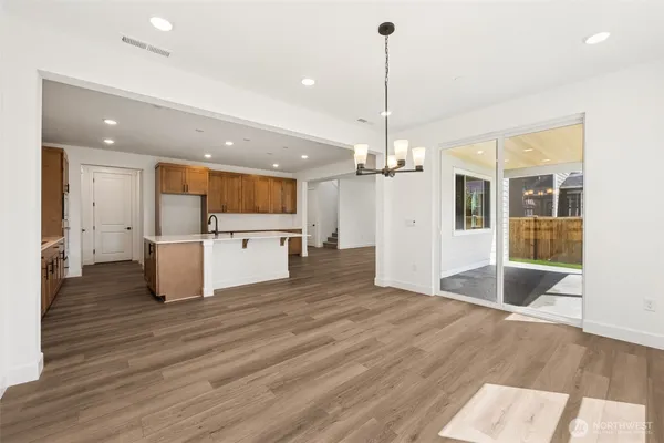 a view of a kitchen with a refrigerator a sink and wooden floor