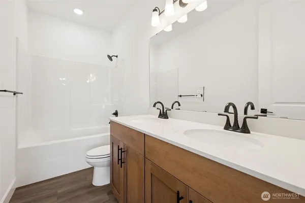 a bathroom with a sink a toilet and a large mirror