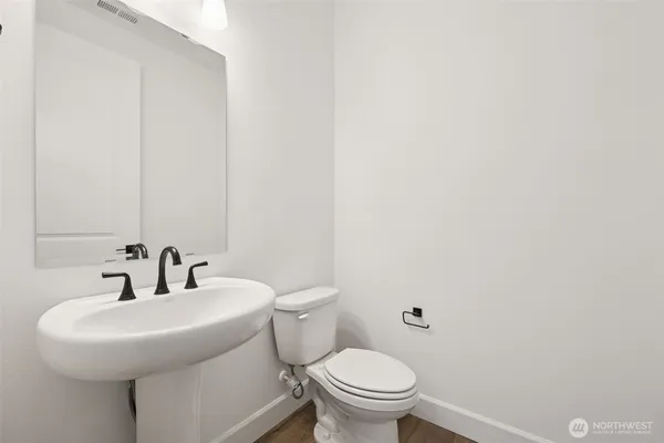 a bathroom with a sink a toilet and mirror