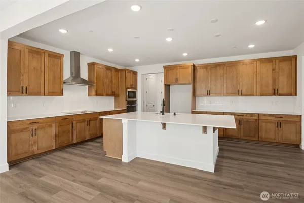 a large kitchen with stainless steel appliances granite countertop a large counter top a sink and a stove