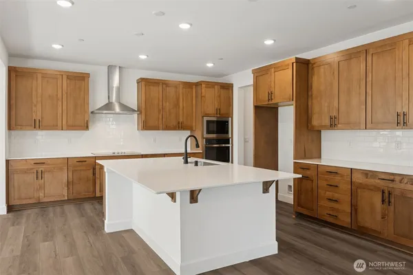 a kitchen with stainless steel appliances granite countertop a sink a refrigerator and a stove