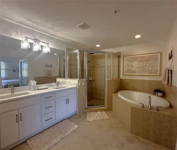a bathroom with a bathtub shower sink mirror and toilet
