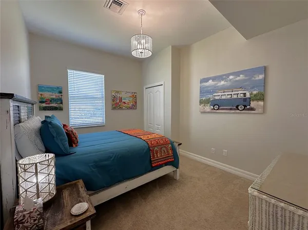a bedroom with a bed and a chandelier