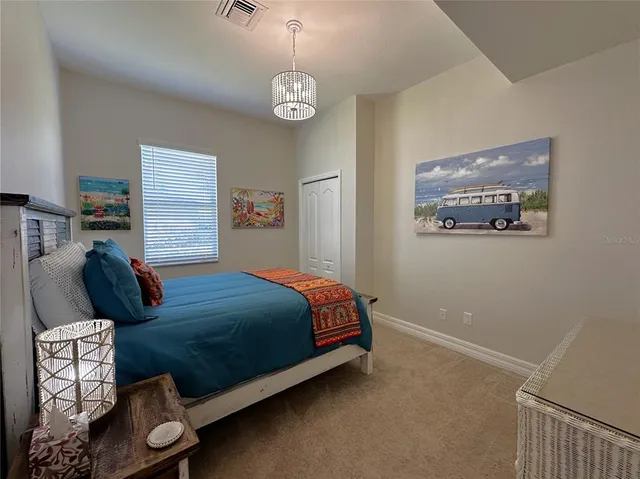 a bedroom with a bed and a chandelier