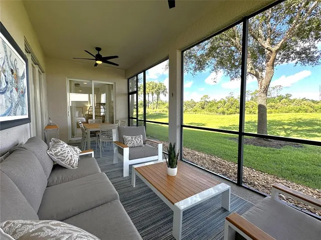 a living room with furniture and a floor to ceiling window