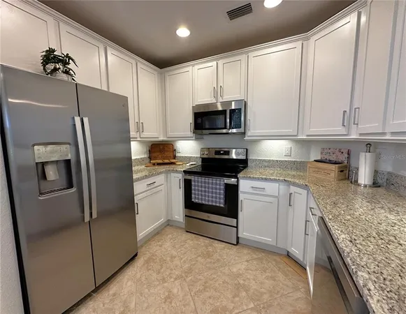 a kitchen with stainless steel appliances granite countertop a refrigerator sink and stove