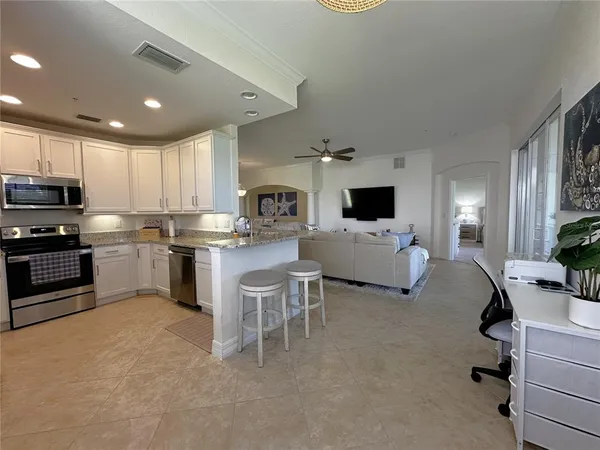 a kitchen with a sink a counter top space appliances and cabinets