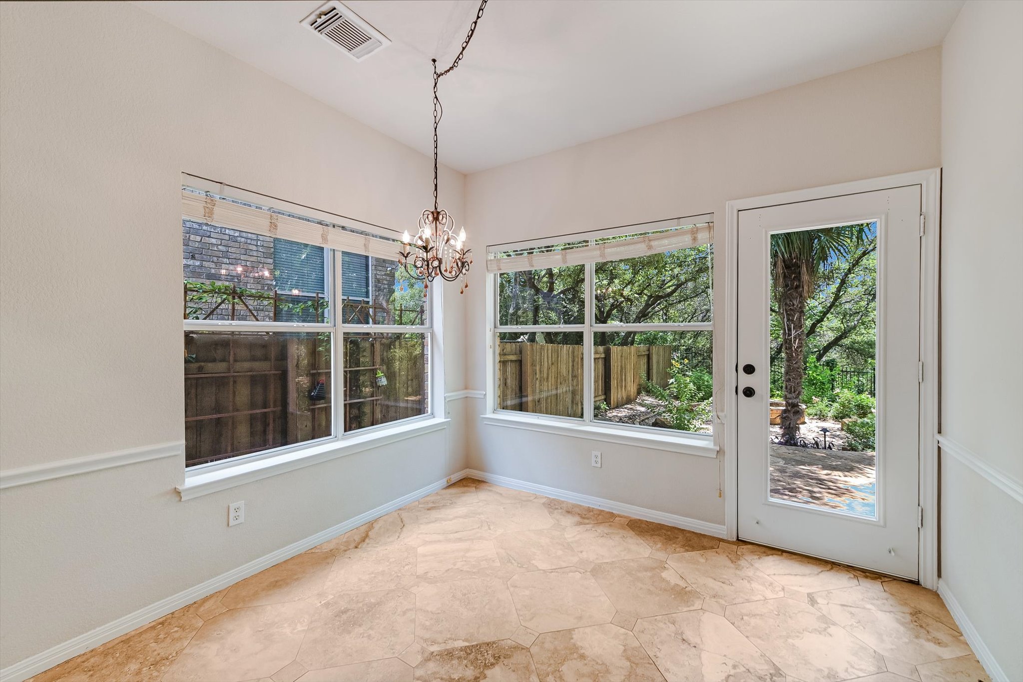 2849 Grimes Ranch Road Austin, TX 78732 - Photo 13 of 31 A well-lit room showcasing a patterned tile floor and views of the garden through multiple windows.