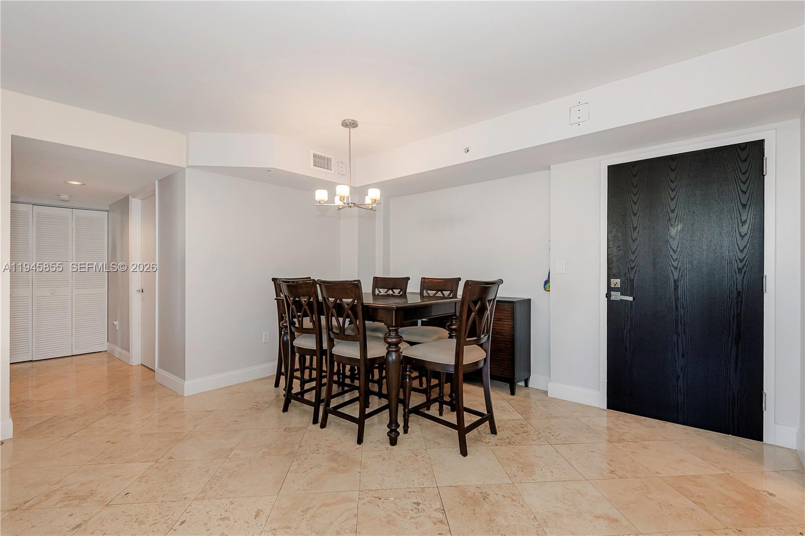 90 Alton Road, Unit 301 Miami Beach, FL 33139 - Photo 13 of 30 a view of a dining room with furniture and chandelier
