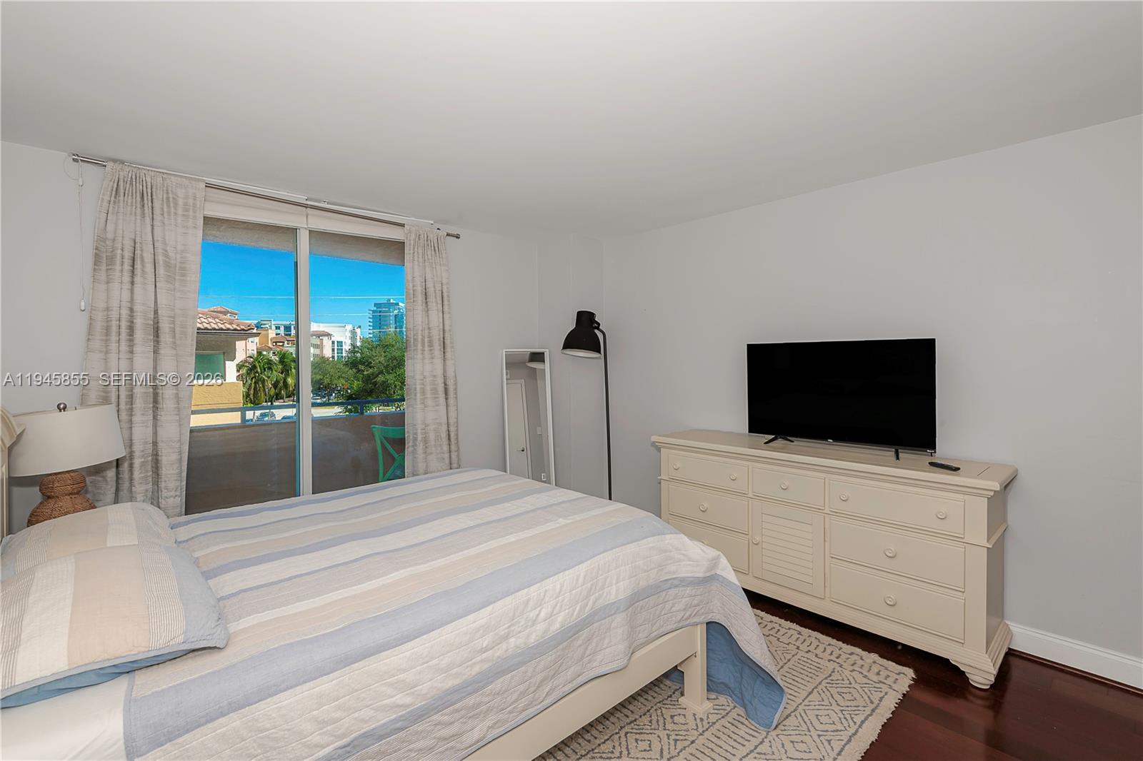 90 Alton Road, Unit 301 Miami Beach, FL 33139 - Photo 22 of 30 a bedroom with a bed and a flat screen tv