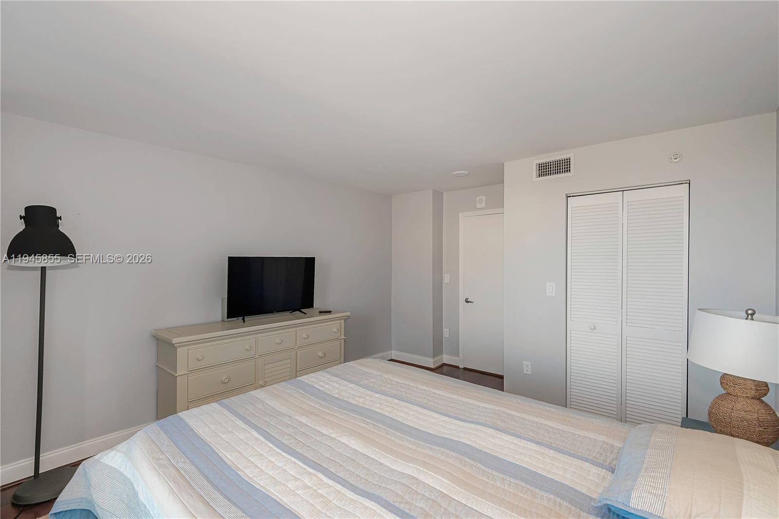 90 Alton Road, Unit 301 Miami Beach, FL 33139 - Photo 24 of 30 a bedroom with a bed and a flat screen tv