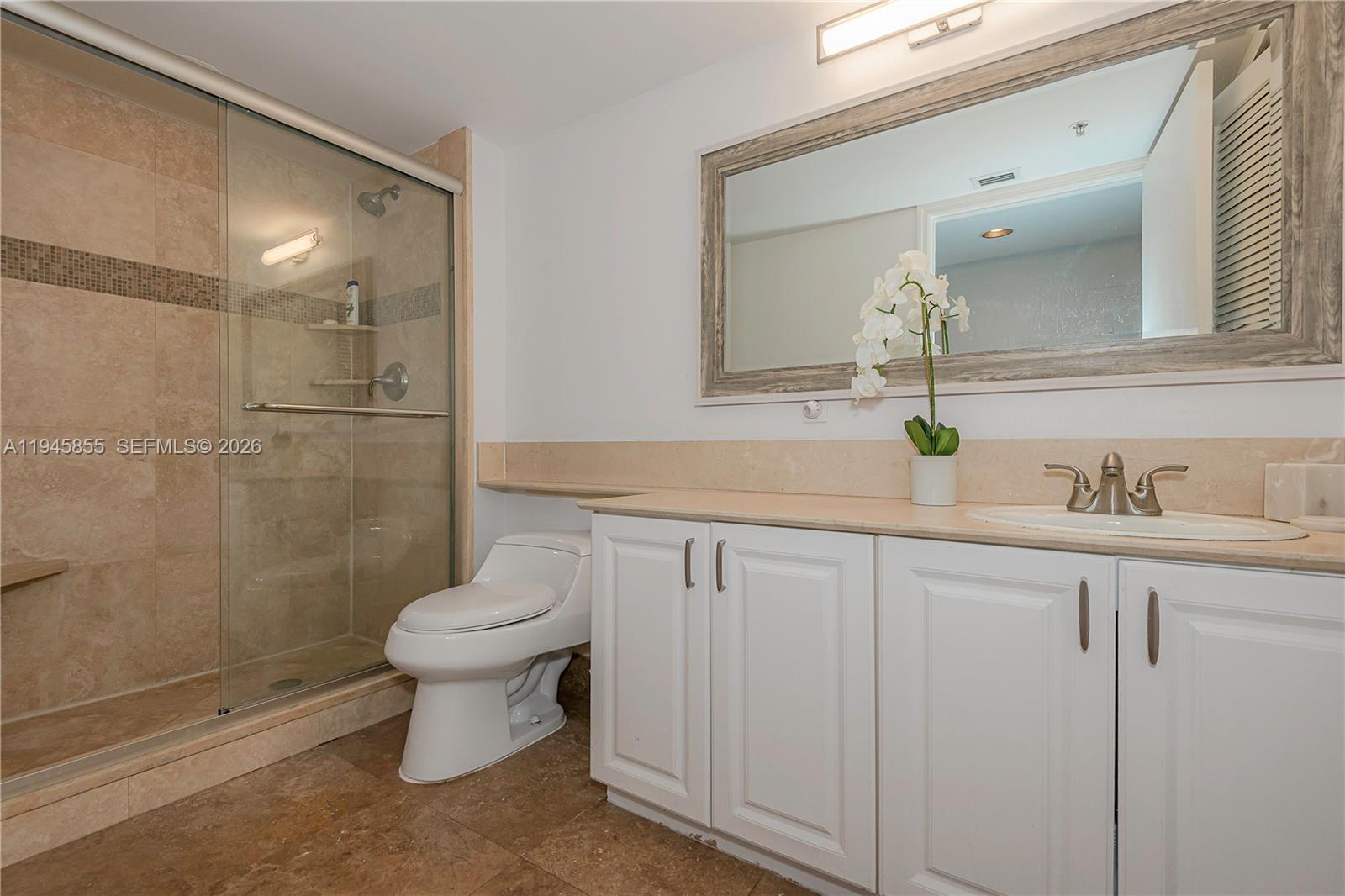 90 Alton Road, Unit 301 Miami Beach, FL 33139 - Photo 26 of 30 a bathroom with a sink and a mirror