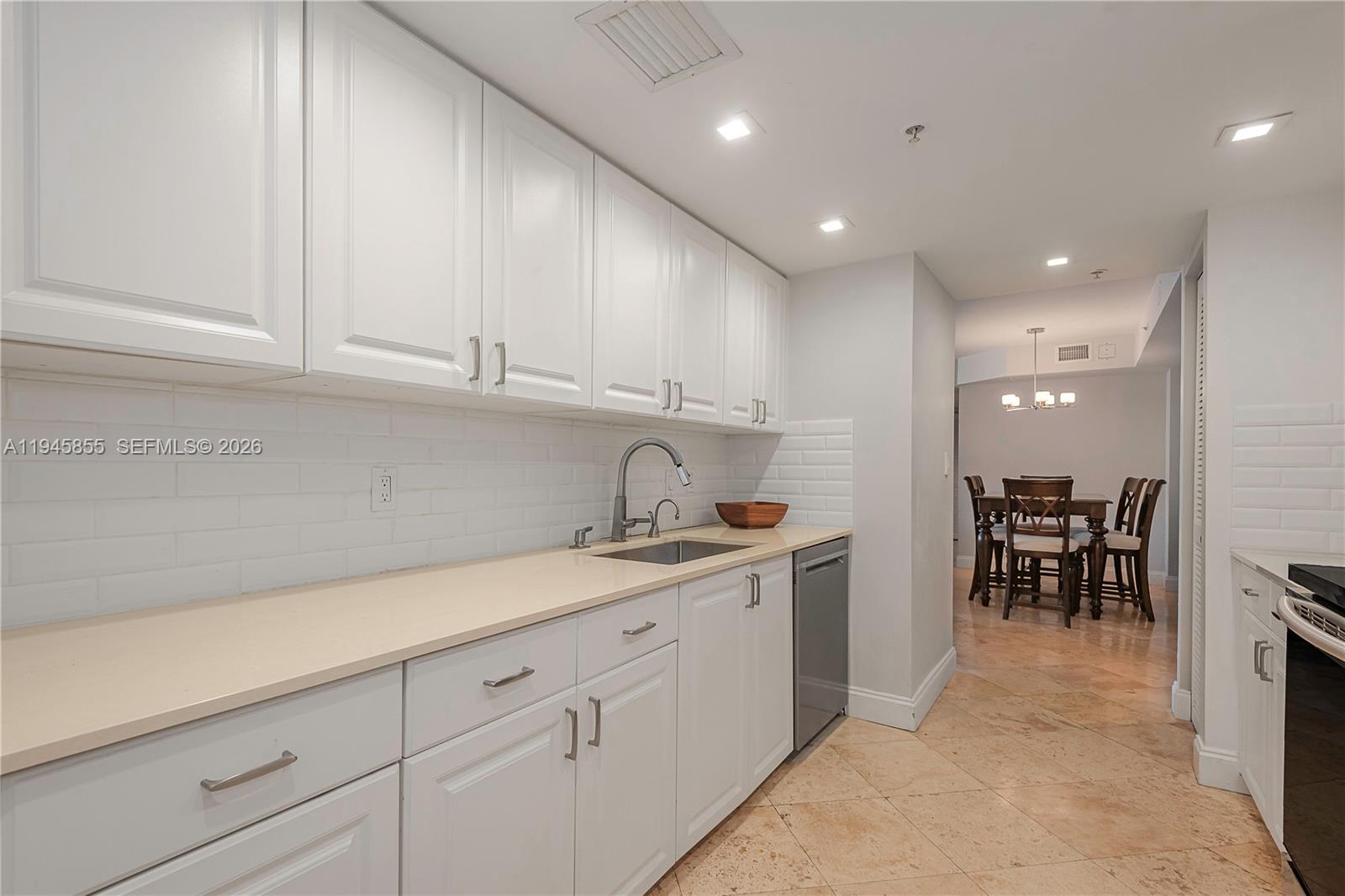 90 Alton Road, Unit 301 Miami Beach, FL 33139 - Photo 4 of 30 a kitchen with a sink and cabinets