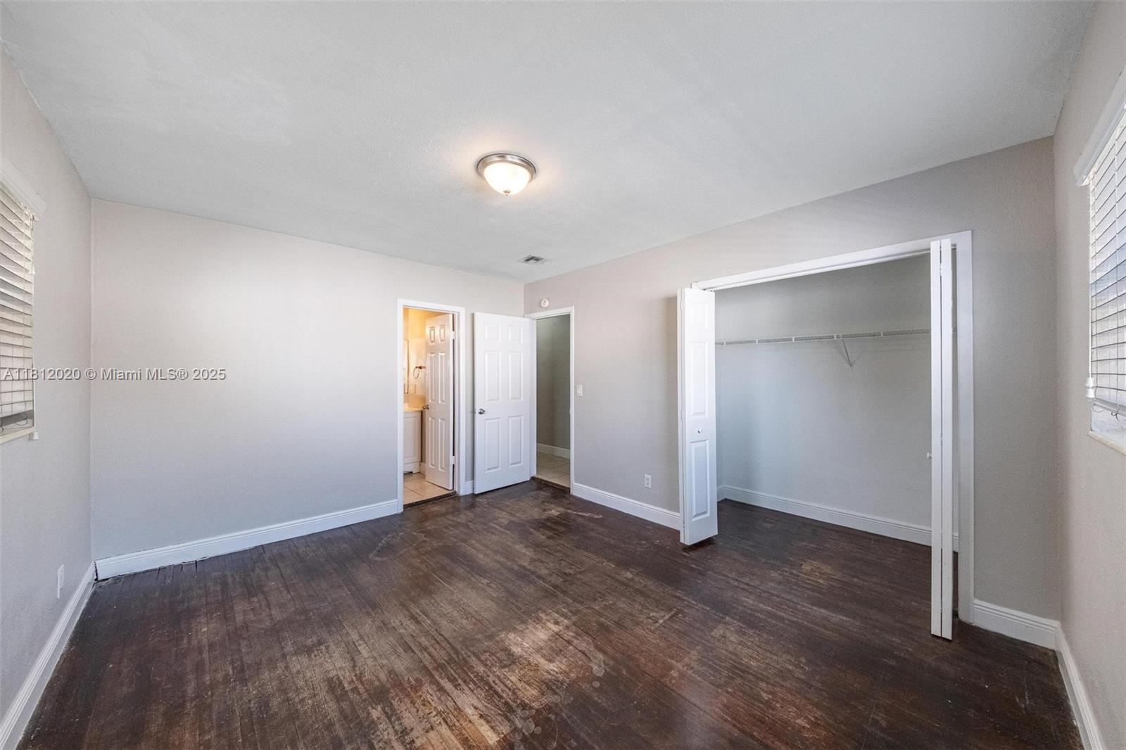 725 Northeast 178th Street Miami, FL 33162 - Photo 12 of 44 an empty room with wooden floor & closet area