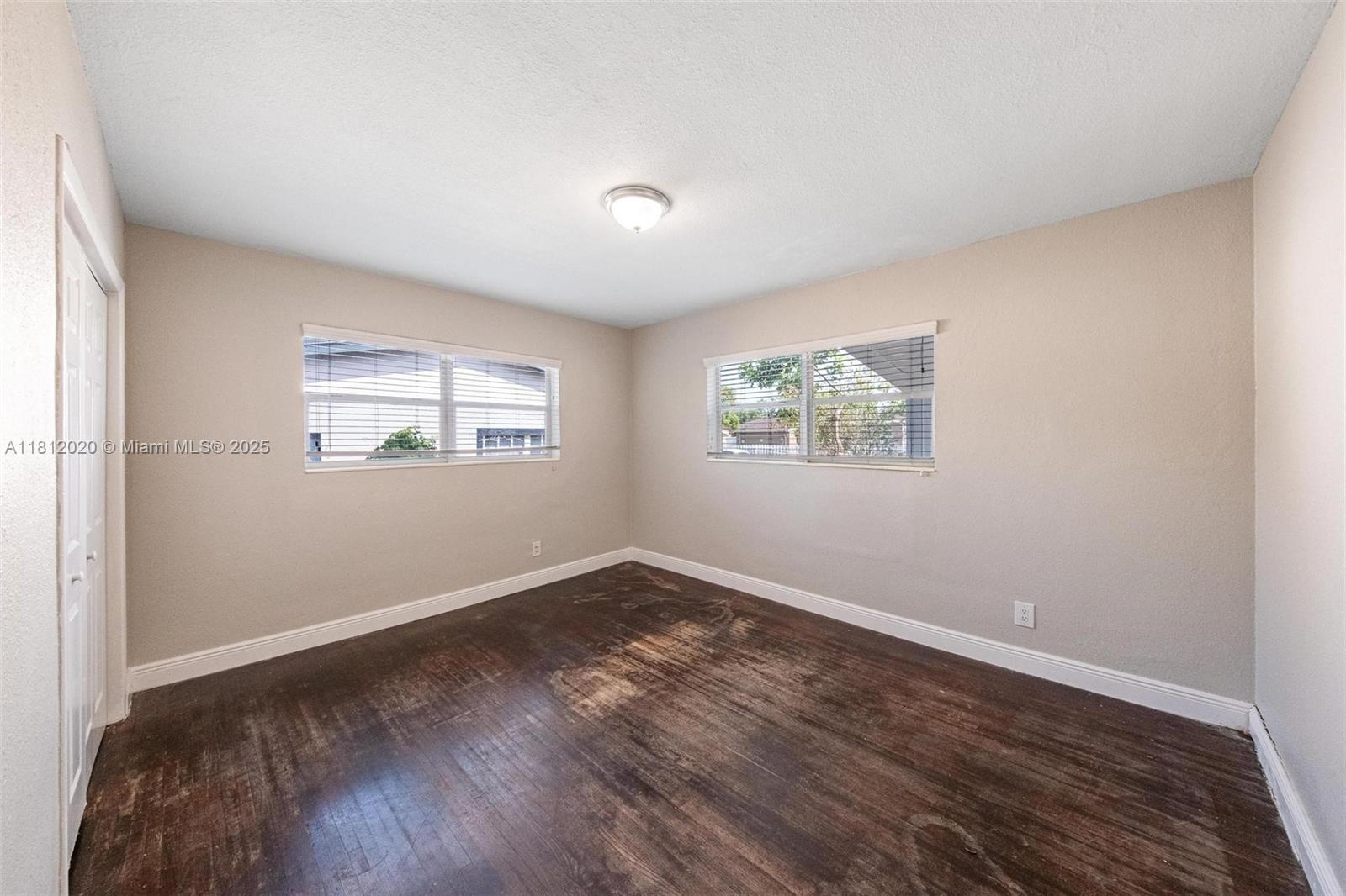 725 Northeast 178th Street Miami, FL 33162 - Photo 13 of 44 a view of an empty room with wooden floor and a window