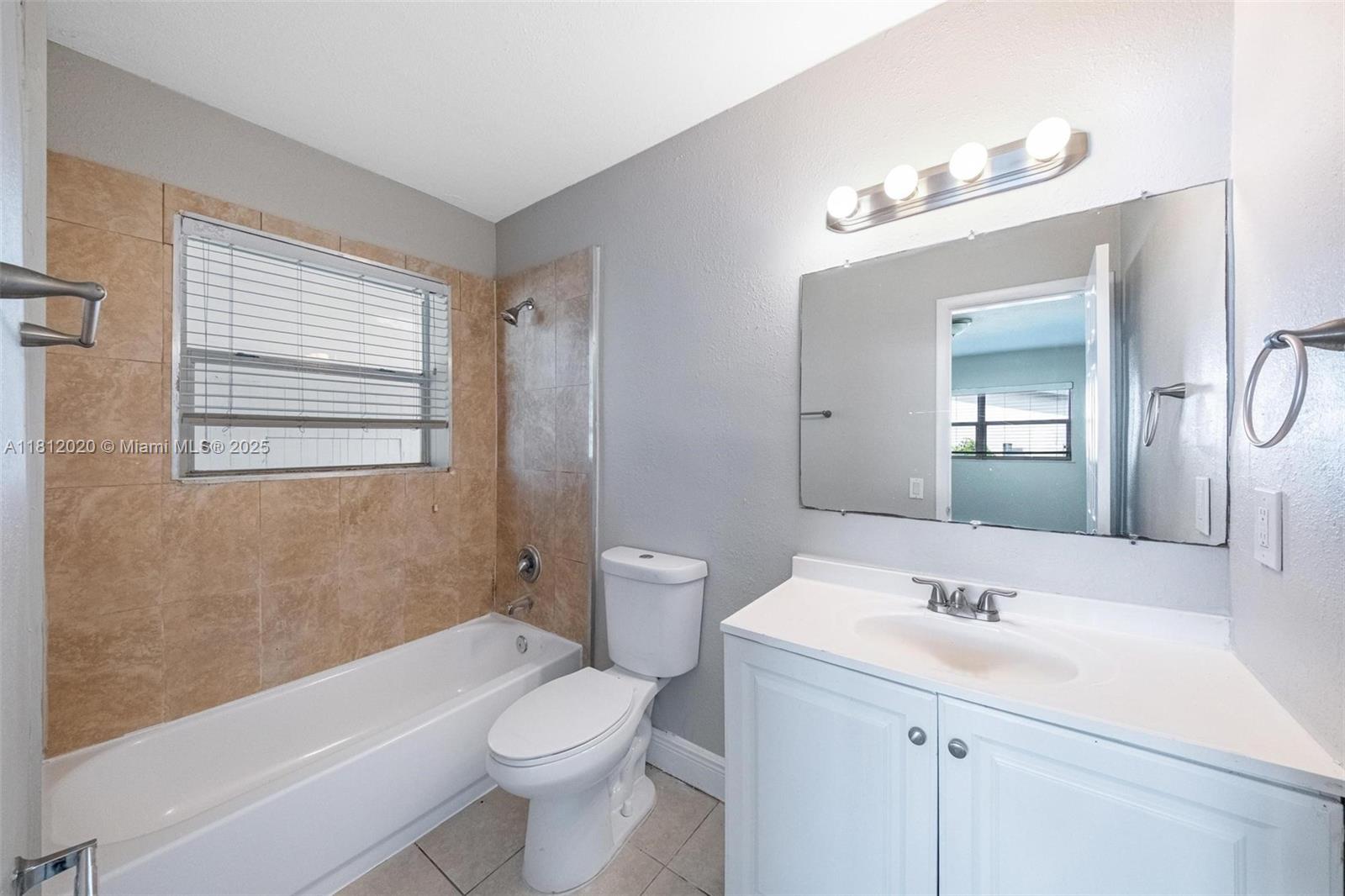 725 Northeast 178th Street Miami, FL 33162 - Photo 14 of 44 a bathroom with a sink a toilet a mirror and shower