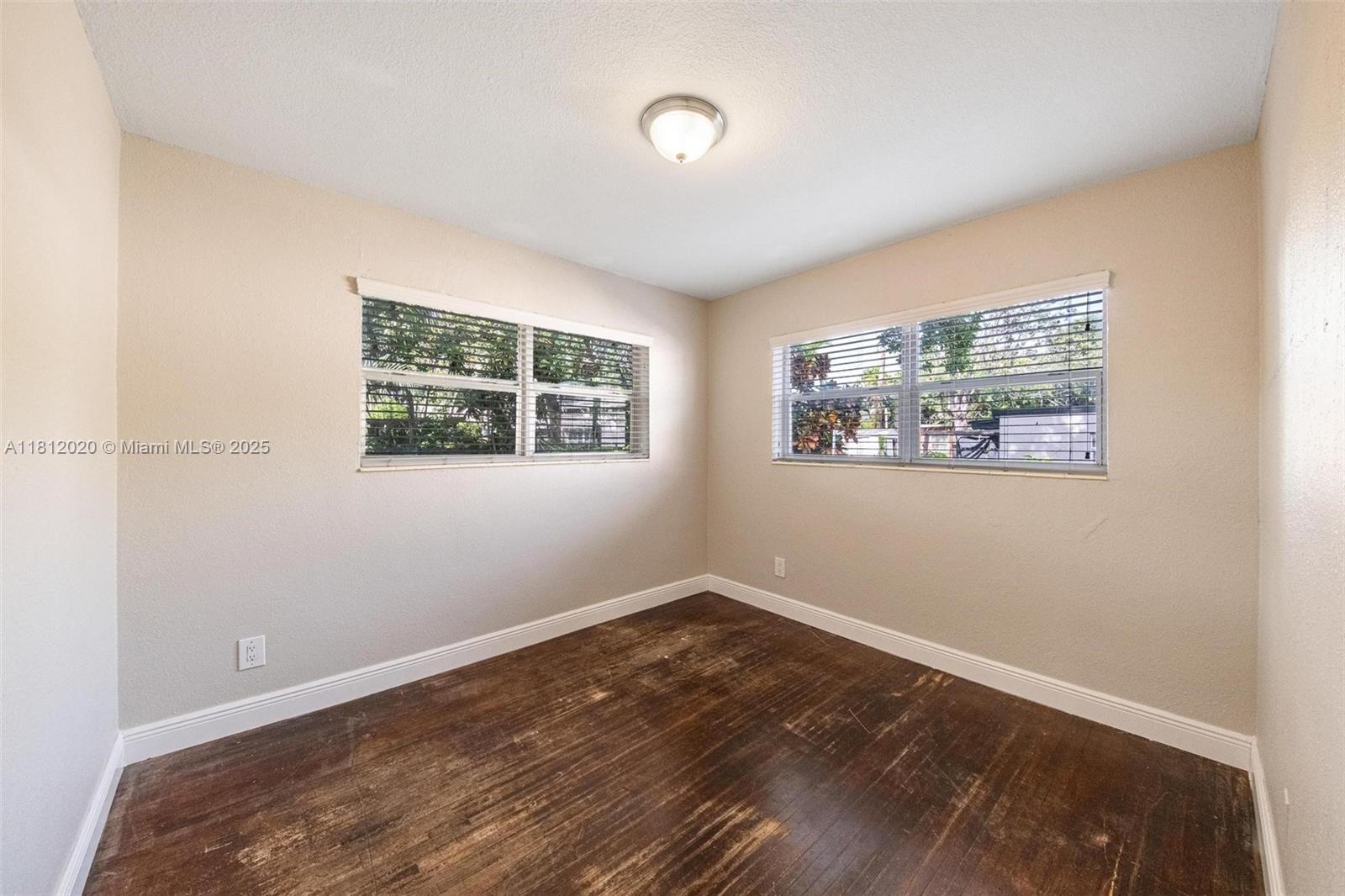 725 Northeast 178th Street Miami, FL 33162 - Photo 15 of 44 a view of a room with wooden floor and window
