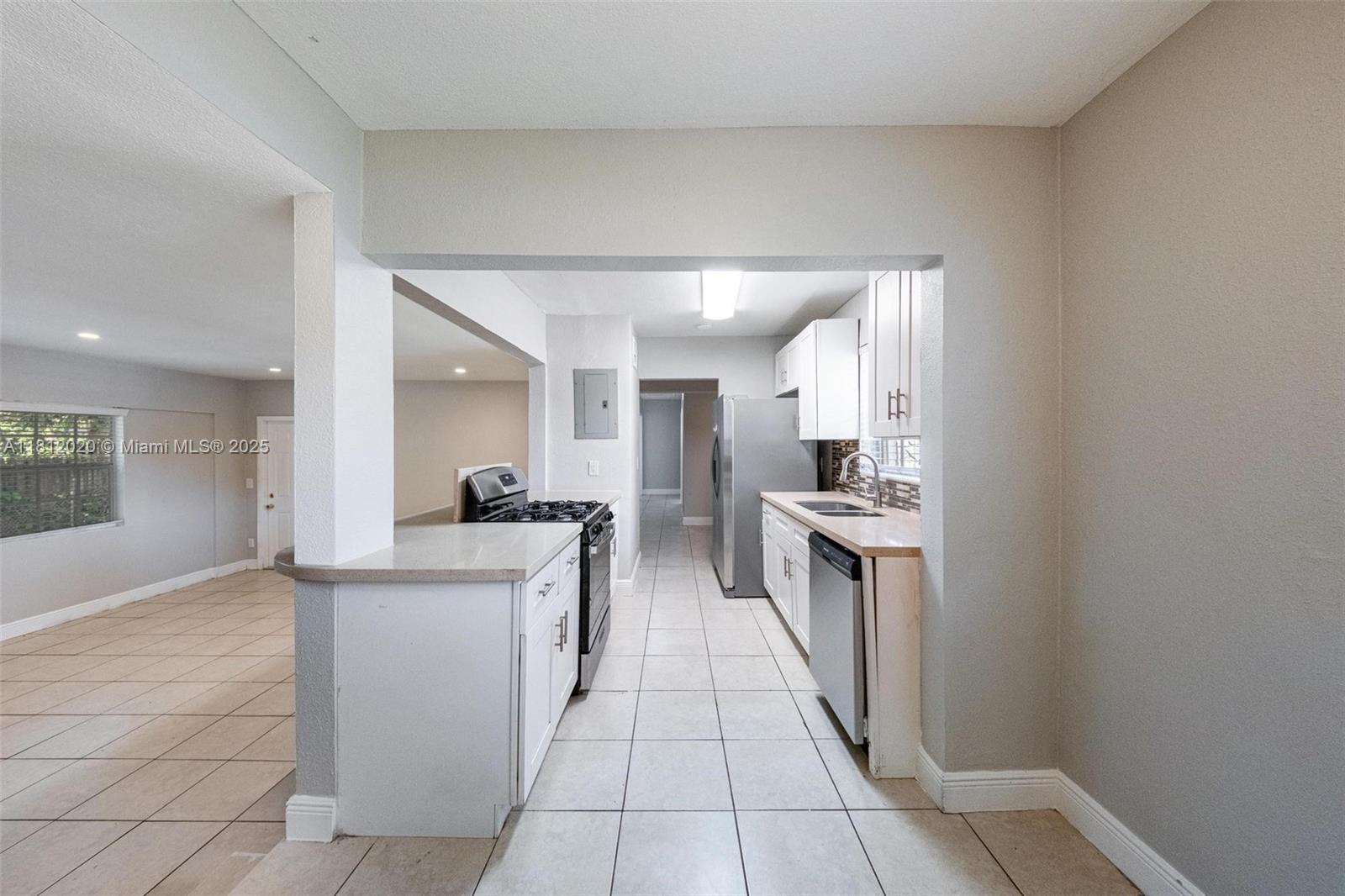 725 Northeast 178th Street Miami, FL 33162 - Photo 17 of 44 a kitchen with a sink and white cabinets