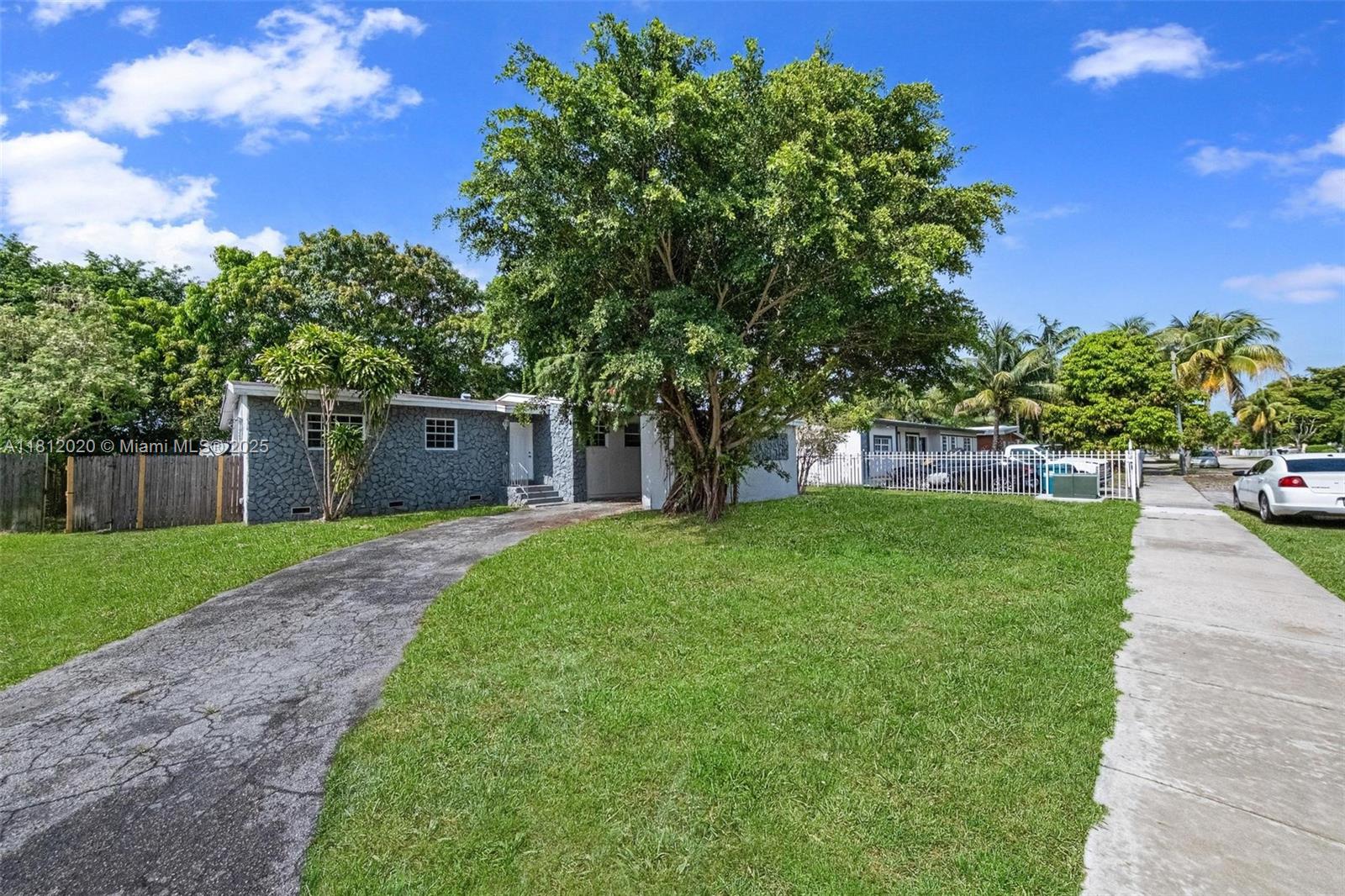 725 Northeast 178th Street Miami, FL 33162 - Photo 2 of 44 a front view of a house with a yard