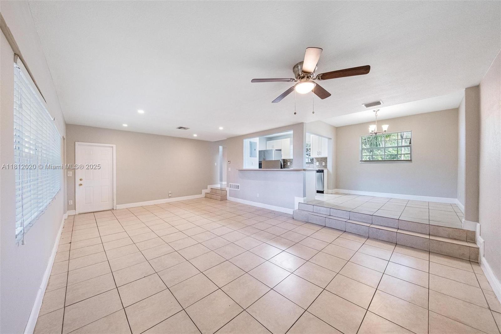 725 Northeast 178th Street Miami, FL 33162 - Photo 21 of 44 a view of an empty room and window and a chandelier fan