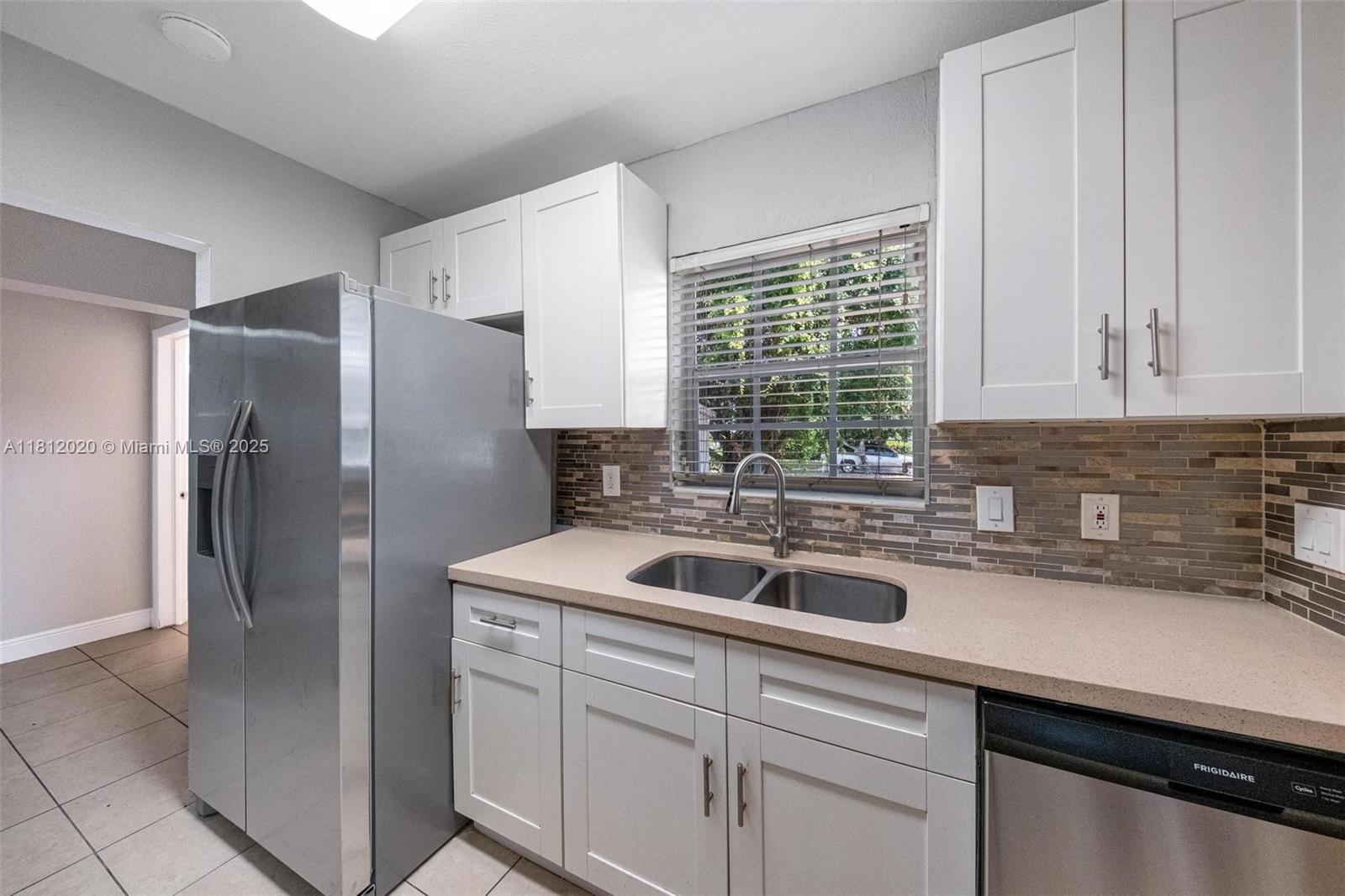 725 Northeast 178th Street Miami, FL 33162 - Photo 29 of 44 a kitchen with a sink and refrigerator