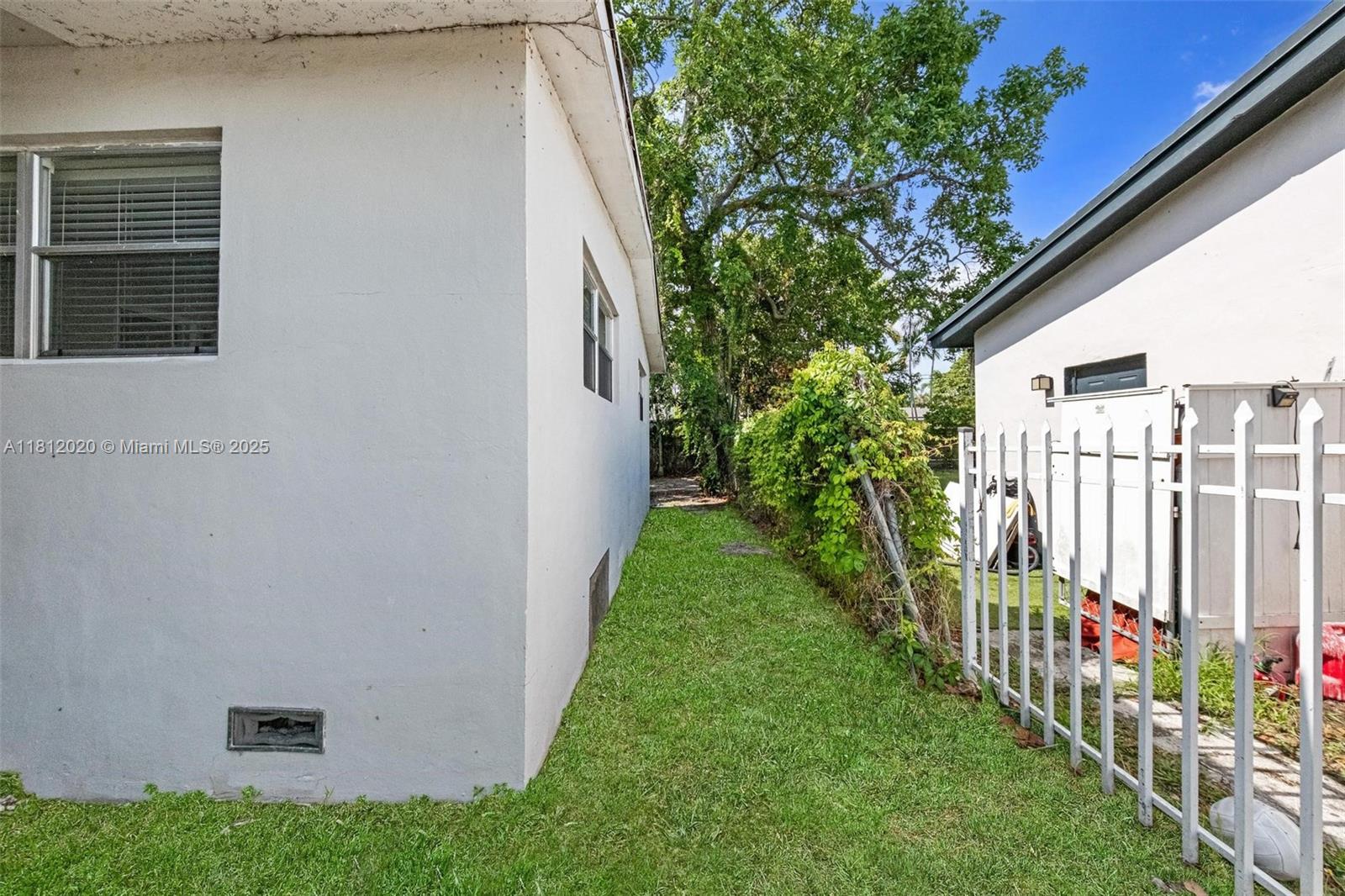 725 Northeast 178th Street Miami, FL 33162 - Photo 32 of 44 a view of a house with a small yard and a large tree