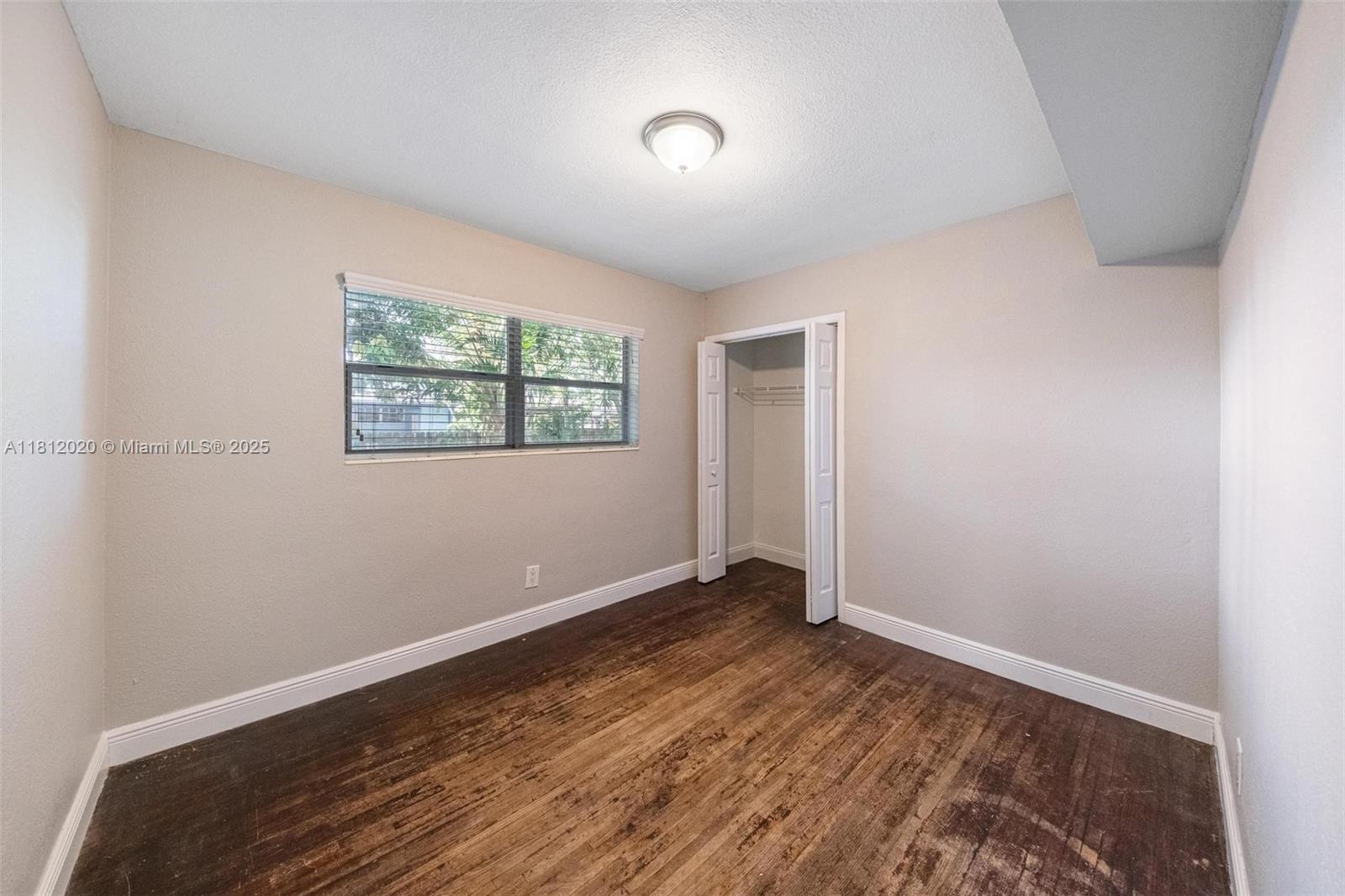 725 Northeast 178th Street Miami, FL 33162 - Photo 8 of 44 an empty room with wooden floor and windows