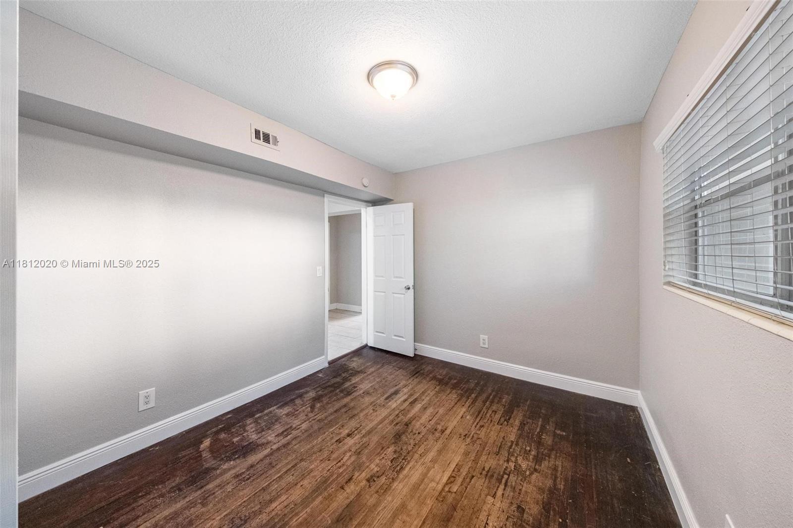 725 Northeast 178th Street Miami, FL 33162 - Photo 9 of 44 a view of room with hardwood floor and window