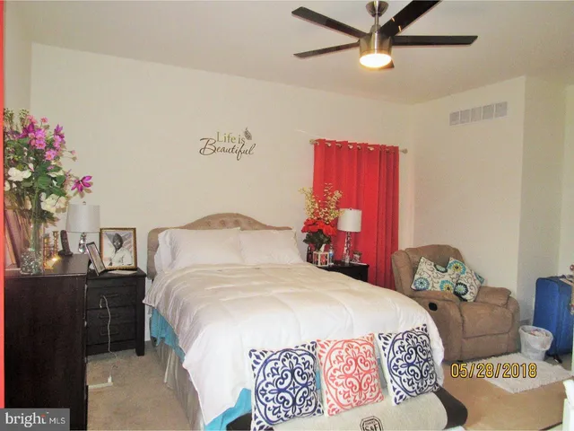 a bedroom with a bed and a potted plant