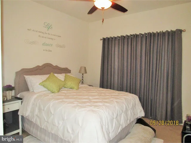 a large white bed in a bedroom next to a window