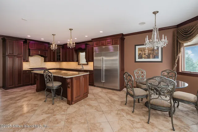 a kitchen with stainless steel appliances granite countertop a stove a refrigerator a oven a sink with a dining table and chairs