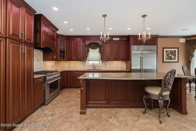 a kitchen with kitchen island granite countertop wooden cabinets and stainless steel appliances