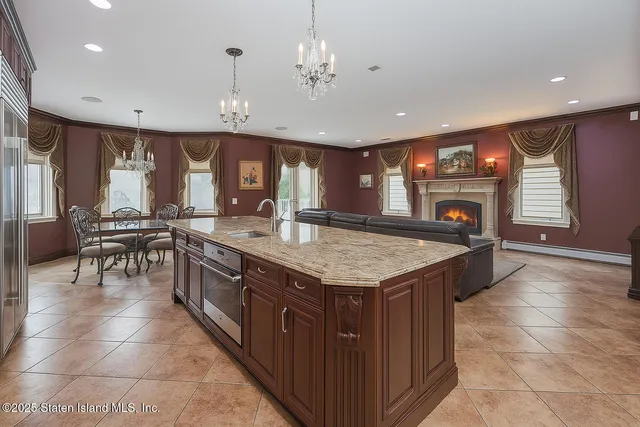a kitchen with stainless steel appliances granite countertop a sink a stove and a wooden cabinets