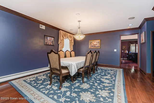 a dining room with furniture wooden floor a rug and a chandelier