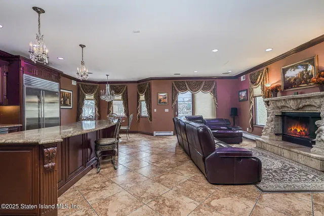 a living room with furniture a fireplace and a chandelier