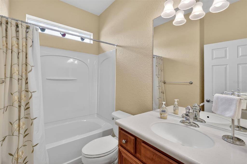7271 Southwest 95th Court Ocala, FL 34481 - Photo 25 of 39 a bathroom with a sink a toilet a mirror a bathtub and shower