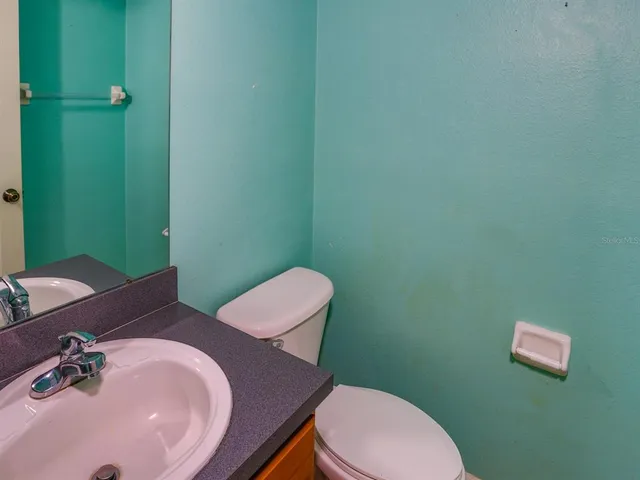 a bathroom with a sink mirror and toilet